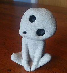 a small white toy sitting on top of a wooden table