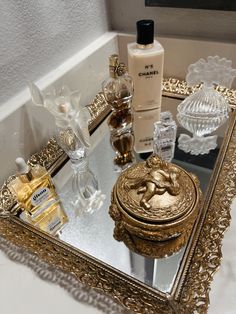 a mirror with some bottles on top of it and a gold box in the middle