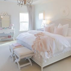 a bedroom with a white bed and chandelier