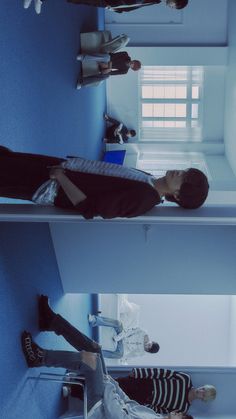 three people are sitting on bunk beds in a room with blue walls and white floors