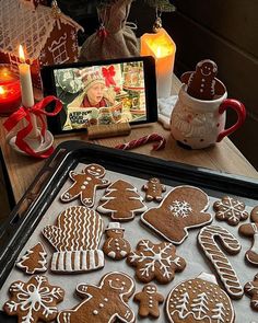 there are many gingerbreads on the table next to candles and a cell phone