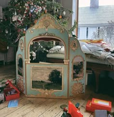 a christmas tree is in the middle of a room with toys and other items on the floor