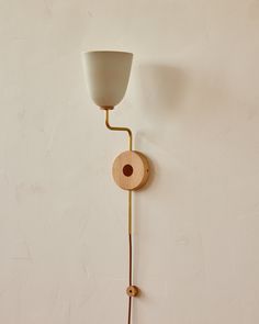 a wall lamp with a wooden base and white glass shade