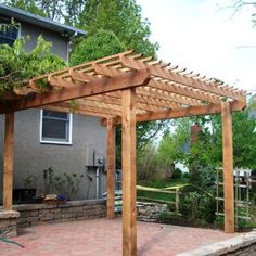 a wooden pergolan sitting on top of a brick patio