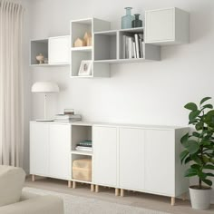 a living room with white furniture and bookshelves