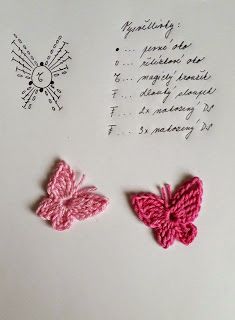 two crocheted butterflies sitting on top of a piece of paper next to a handwritten note