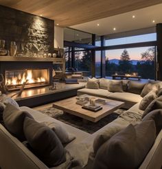 a living room filled with furniture and a fire place in front of a large window