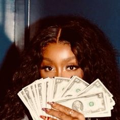 a woman covering her face with money