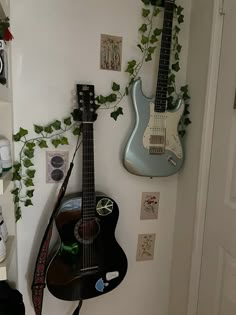 two guitars are hanging on the wall next to each other in a room with white walls