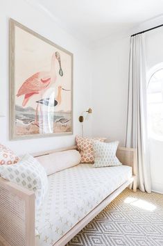 a living room with a white couch and painting on the wall above it's headboard