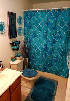 a bathroom with a blue shower curtain and rug