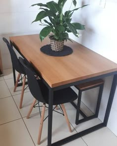 a wooden table with two chairs and a potted plant on top of the table