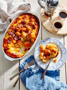 a casserole dish with ham and cheese on it next to a cup of coffee