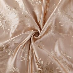 a close up view of a satin fabric with gold flowers and leaves on the side