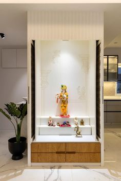 a display case filled with figurines on top of a marble counter next to a potted plant