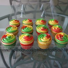 cupcakes with colorful frosting sitting on a glass table