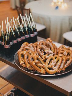 some pretzels are sitting on a table with bottles of soda and straws