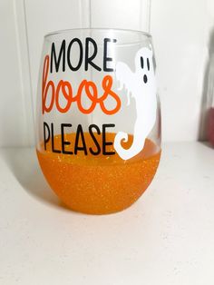 a wine glass that says, more boos please on it with an orange inside