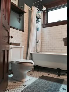 a white toilet sitting next to a bath tub in a bathroom