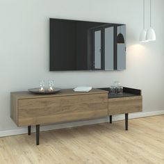 an empty room with a wooden dresser and mirror on the wall, in front of a white painted wall