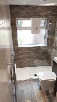 a bathroom with a toilet, sink and bathtub next to a window in the wall