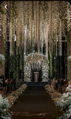 an aisle decorated with white flowers and greenery for a wedding or reception at the same time