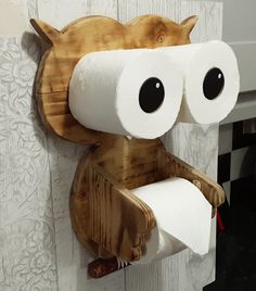 a toilet paper holder made to look like an owl holding a roll of toilet paper