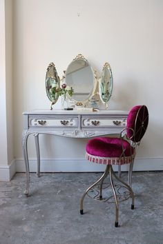 a white desk with a mirror and pink chair