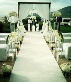 the aisle is lined with white flowers and chairs