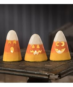 three pumpkin shaped candles sitting on top of a table