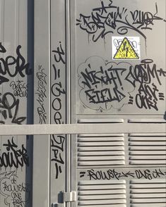 graffiti on the side of a train car with it's door open and windows closed