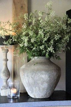 a vase filled with flowers sitting on top of a table next to a lit candle