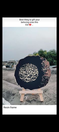 a black plate sitting on top of a table next to a wooden stand with writing on it