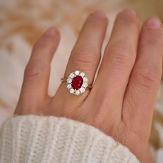 a woman's hand with a red and white ring on it