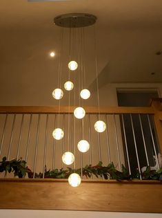 a chandelier hanging from the top of a wooden railing