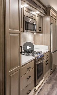 a kitchen with stainless steel appliances and wood flooring in an rv or truck showroom