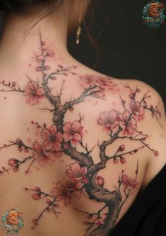 a woman's back with cherry blossom tattoos on it