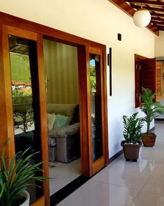 the inside of a house with potted plants on the floor and sliding glass doors