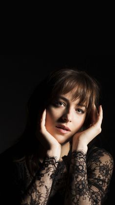 a woman with her hands on her head posing for a photo in black laces