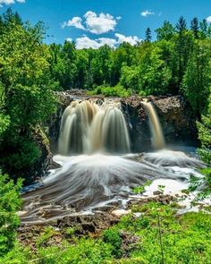 a large waterfall surrounded by trees and water