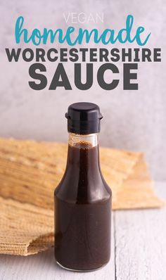 a bottle filled with sauce sitting on top of a wooden table