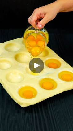 someone is pouring eggs into an egg tray