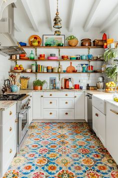 a kitchen with white cabinets and colorful tile flooring on the walls, along with open shelving