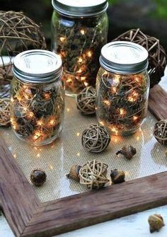 three mason jars filled with fairy lights and twine balls sitting on a wooden table