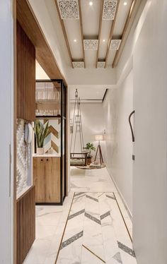 the hallway is decorated in white marble and wood with geometric patterns on the flooring