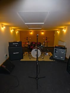 an empty room with guitars, amps and drums on the floor in front of it