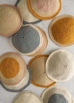 six woven baskets are arranged on a marble surface, each with different colors and sizes