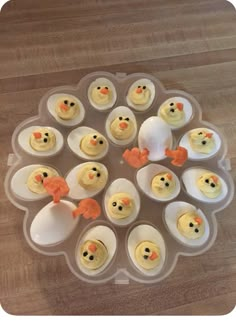 an egg tray filled with deviled eggs topped with frosting and decorated as chickens