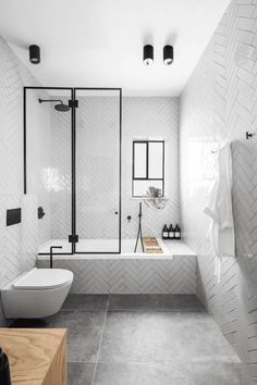 a white bathroom with black accents and tile flooring, along with a free standing tub