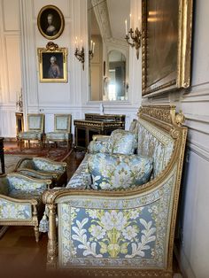 an ornately decorated living room with blue and gold furniture in it's center